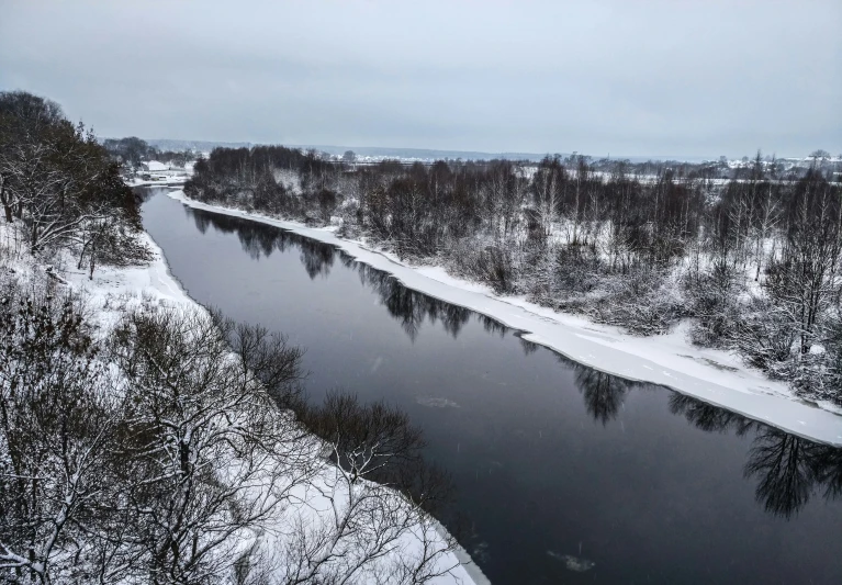 snowy winter landscape looking down at a small river