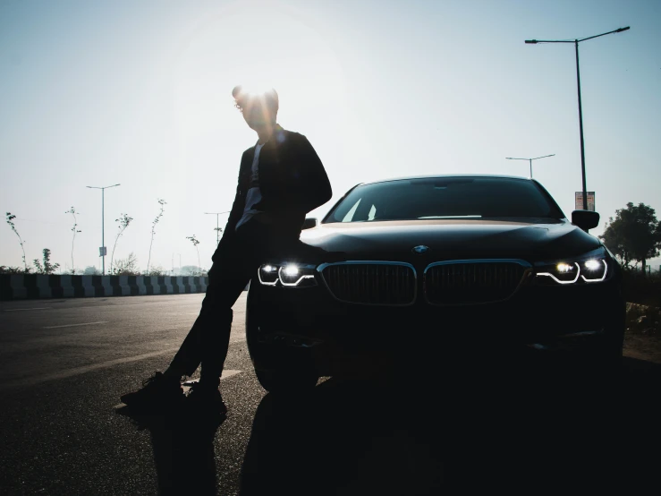 a man walking beside a parked bmw car