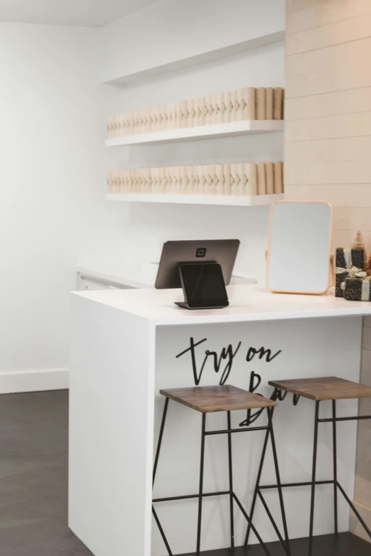 a table that has two stools and a computer on top