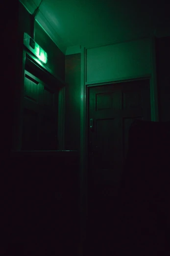 a green door that is next to a dark wall