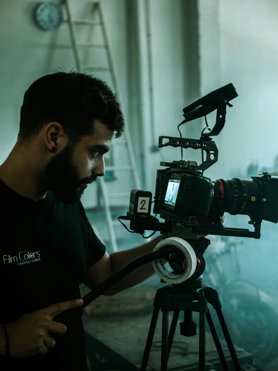 a man operating a camera on a tripod