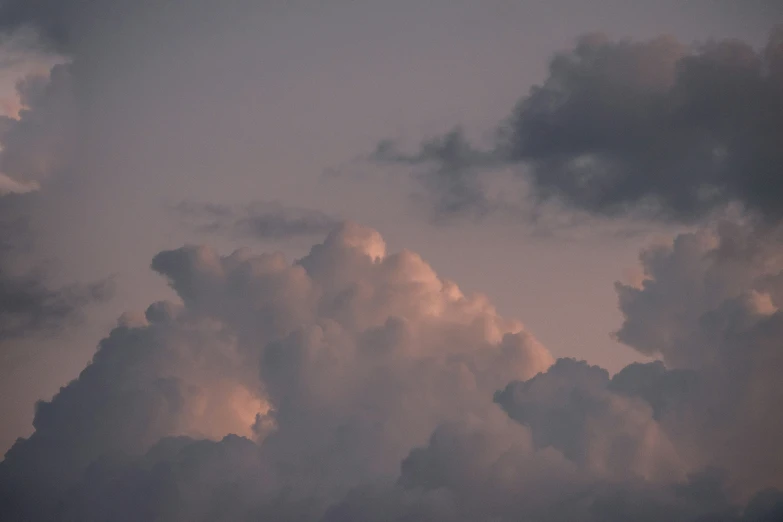 a very cloudy sky with a airplane in it