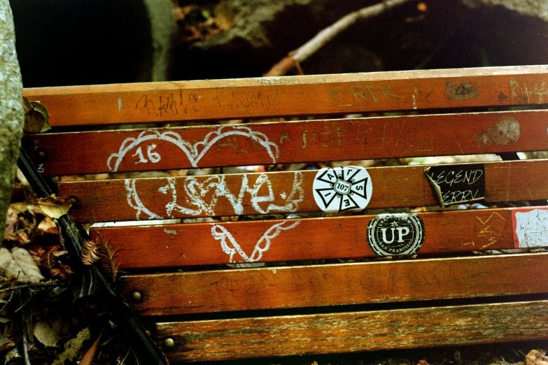 a bench with stickers on it next to leaves