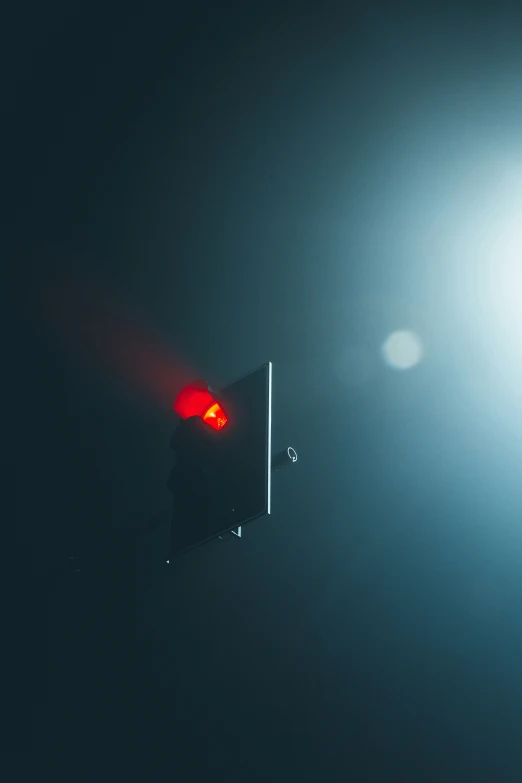 a traffic light in a darkened place, is lit red