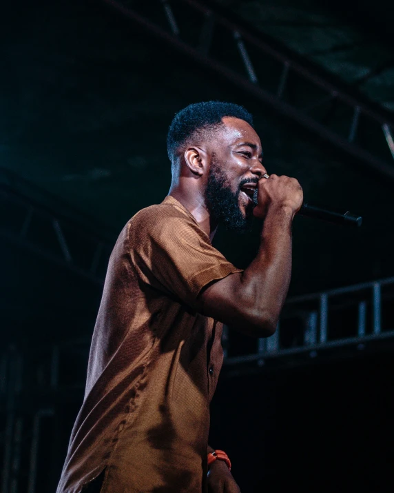 a man singing into microphone at outdoor concert