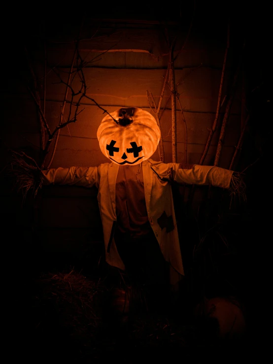 a decorated pumpkin standing in the dark on a house