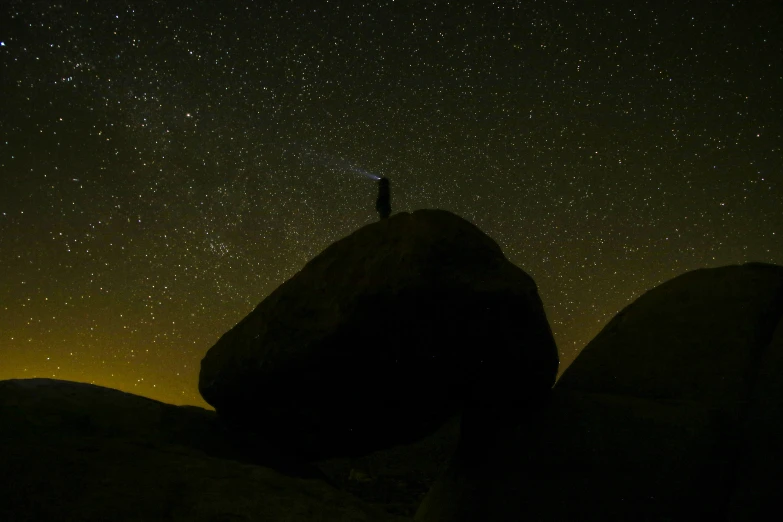 the night sky is shining brightly over the large rocks