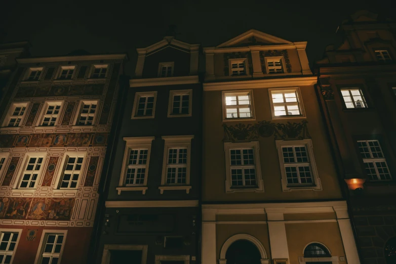 two building side by side at night with a clock on top