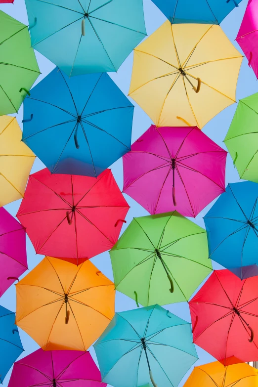 many colorful umbrellas hanging up in a sky