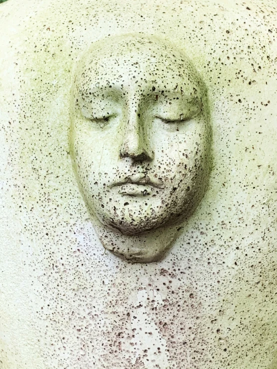 the sculpture of a person with his head covered by freckling