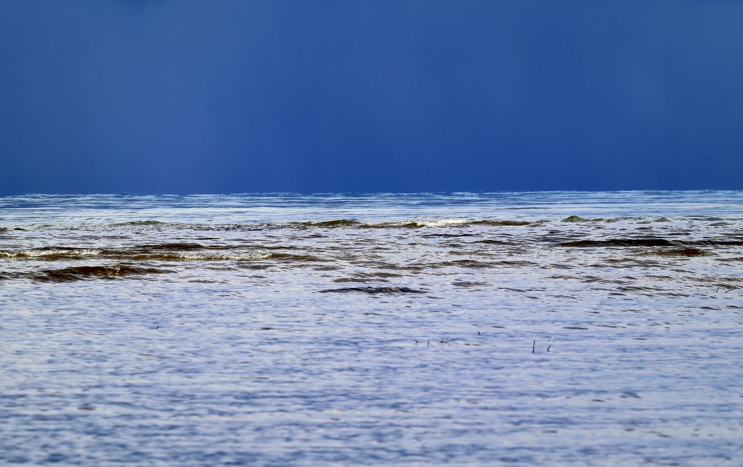 a man is wading in the water at the beach