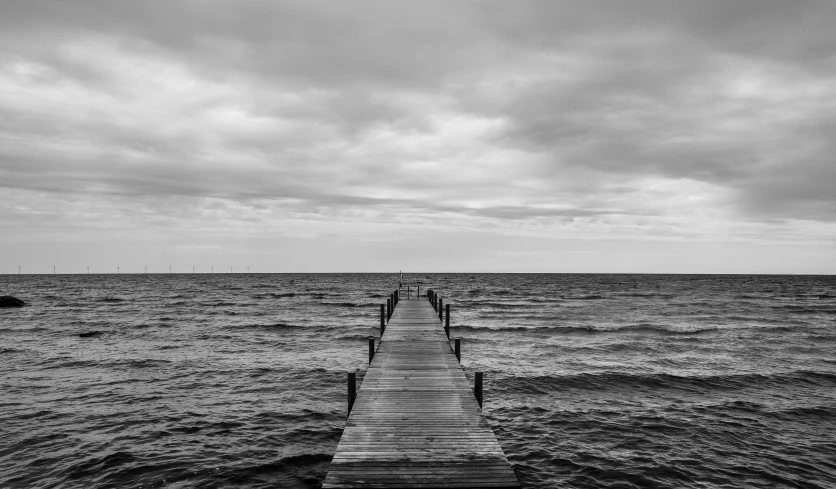 black and white image of the pier on the ocean