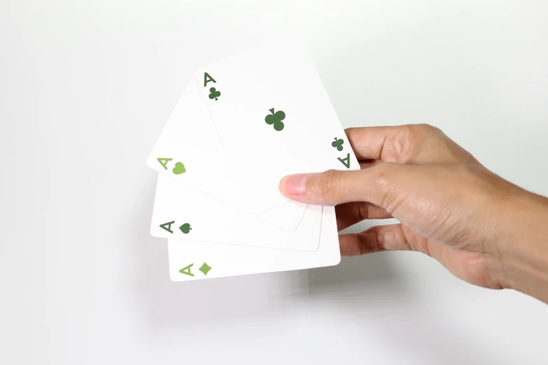 someone holding three card playing cards in their left hand