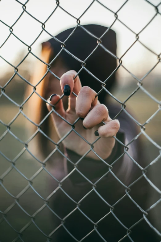 a person holds a finger near a wire fence
