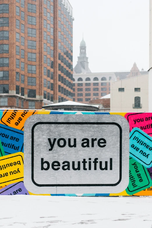 a sign with different messages and a building behind it