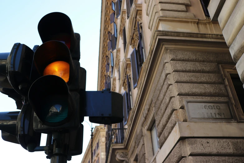 close up po of stoplight with buildings in the background