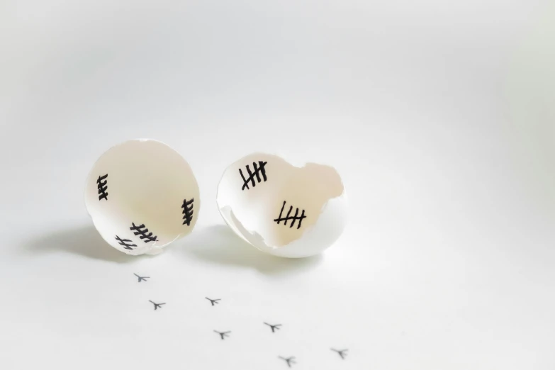 a pair of small round white studs with black letters