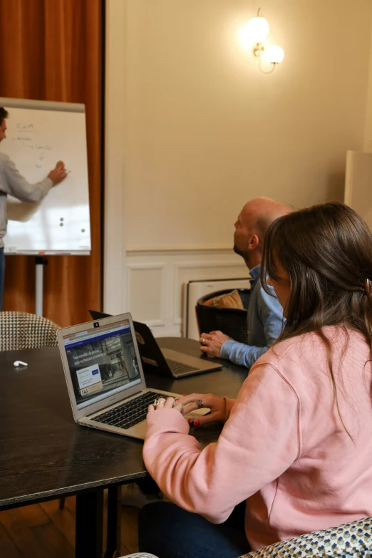 two people at a table with laptop computers