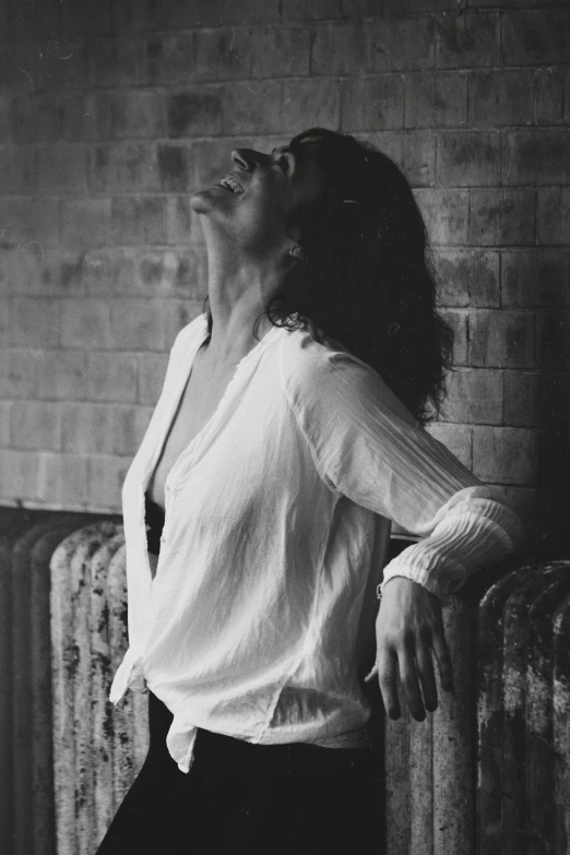 a woman that is standing up in front of a brick wall