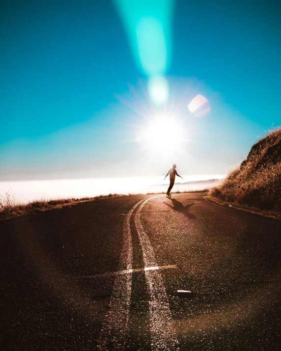 man walking down road, toward the ocean