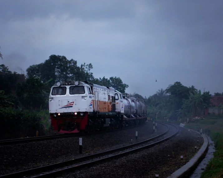 a train passing down some tracks near trees