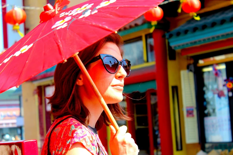 woman in red dress holding pink umbrella and shopping bags