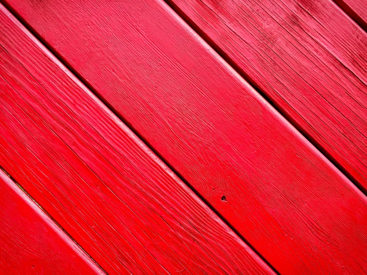 the wood of an old red building, painted bright red