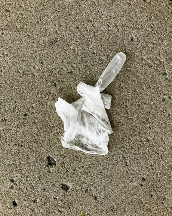 a plastic bag and garbage sitting on sand