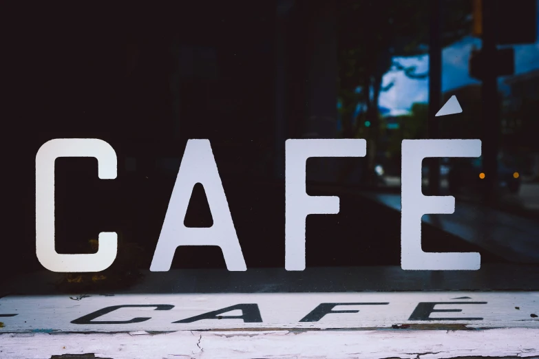 a cafe sign that has the word cafe painted on it