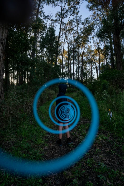 a man is standing in a blue ring by a tree