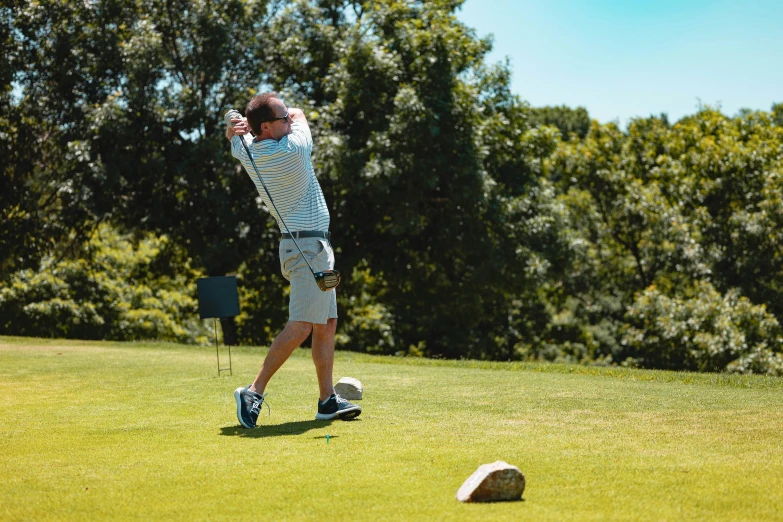 an older man hitting golf balls on a golf course