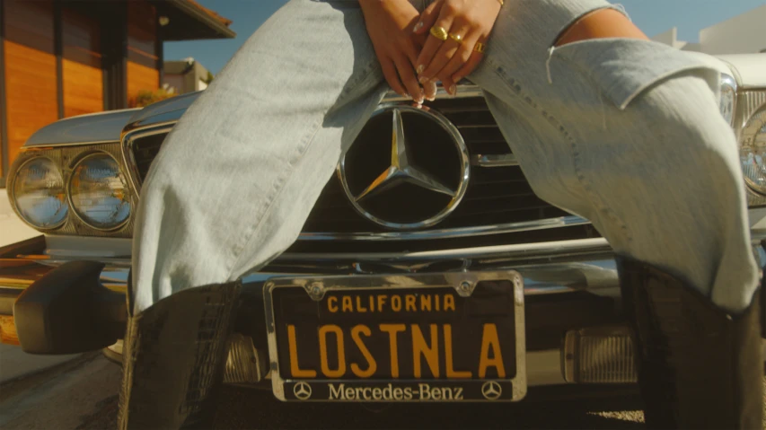 a person that is standing on top of a mercedes car