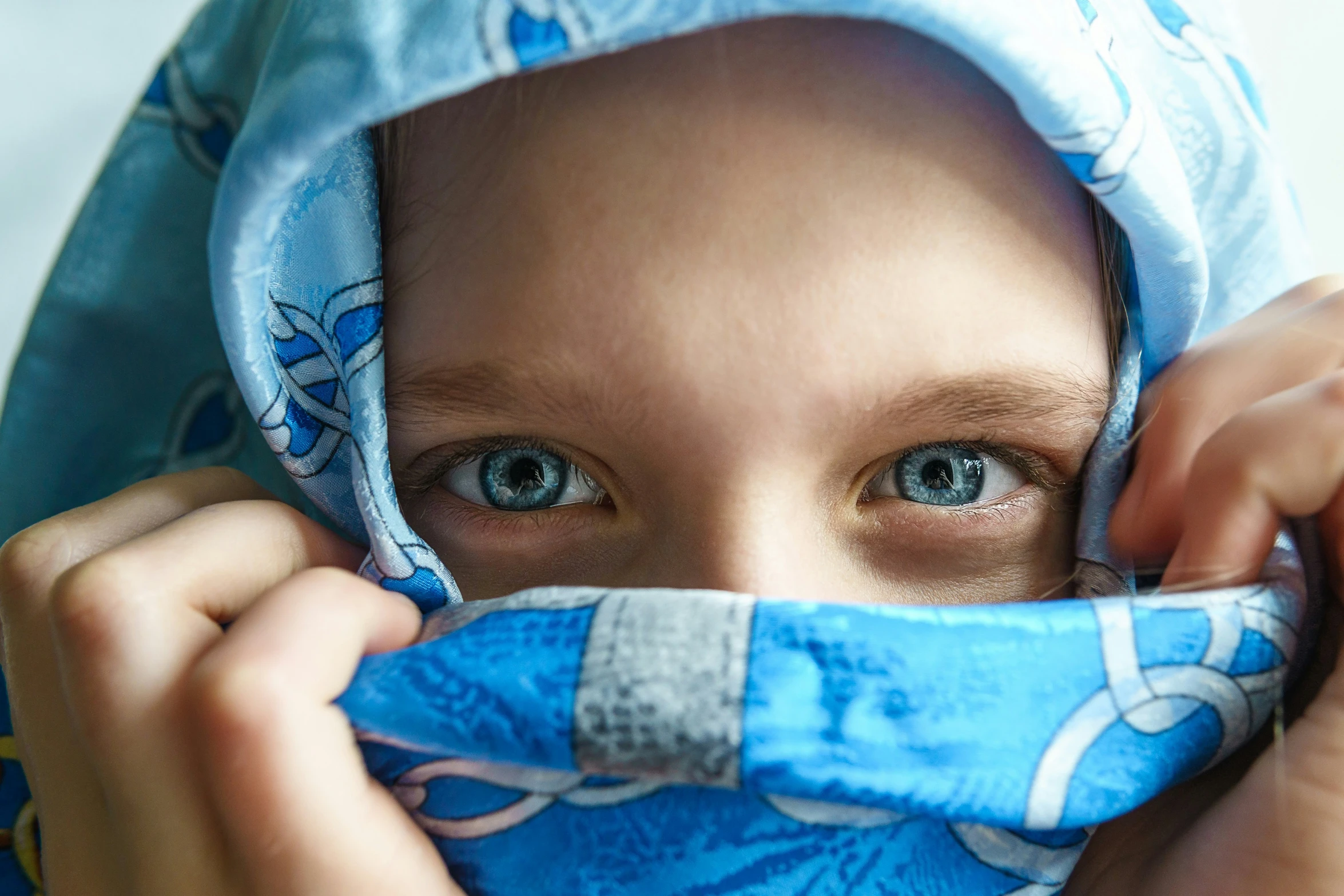 a  has his face hidden by a blue towel