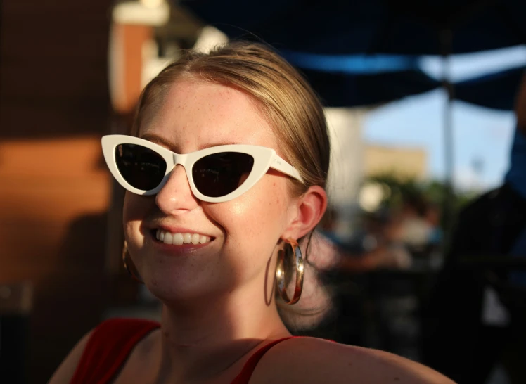 the lady is wearing large glasses and smiling