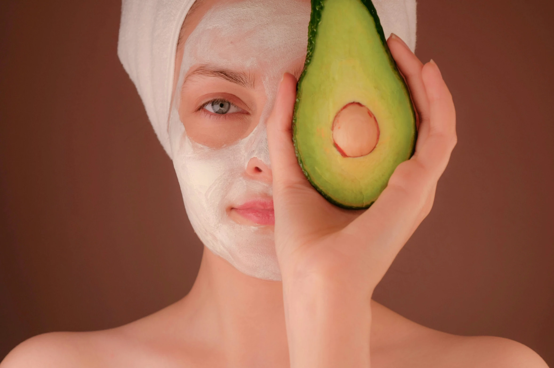 the woman is holding an avocado up to her face