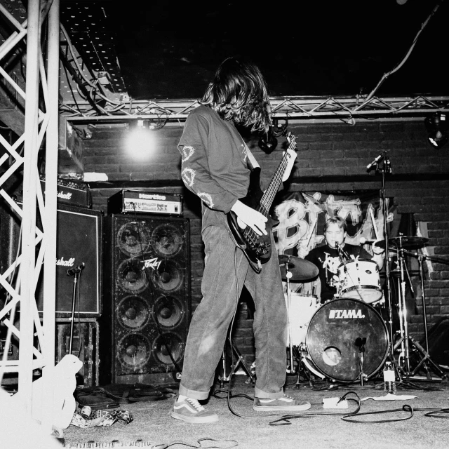 a man standing on a stage playing guitar