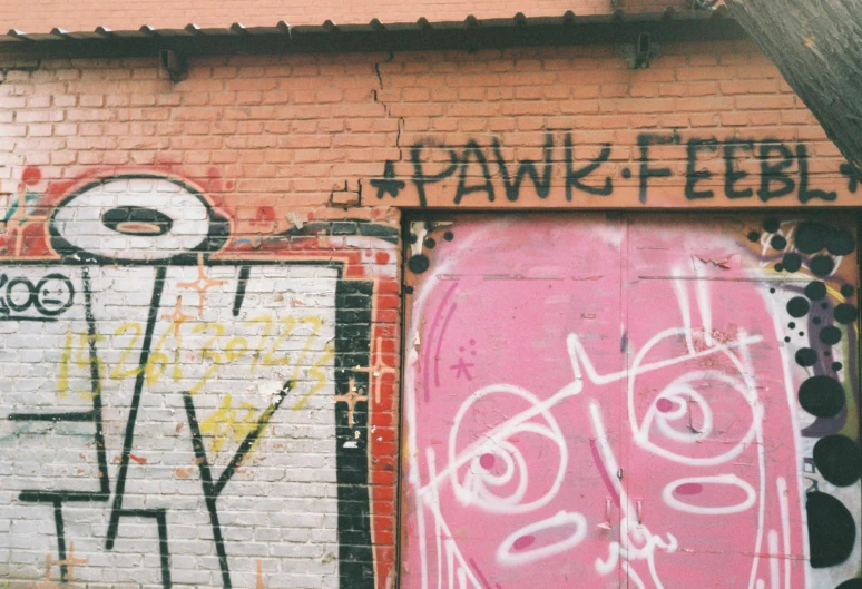 a pink building with graffiti on the front and side