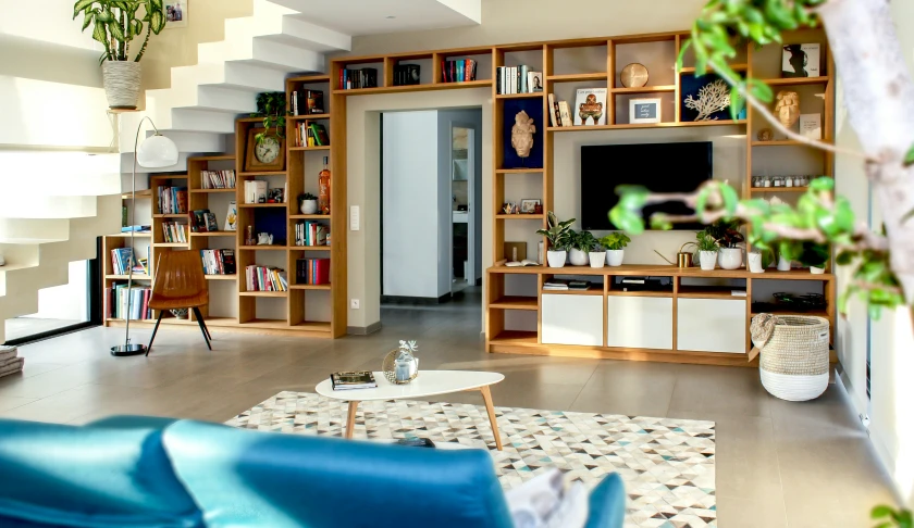 the living room has been decorated with wooden bookshelves and a wall of shelves