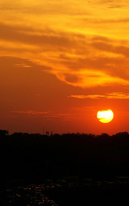 a sunset with an airplane flying over the sun setting