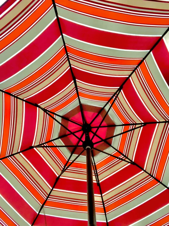 the inside of an orange and white umbrella