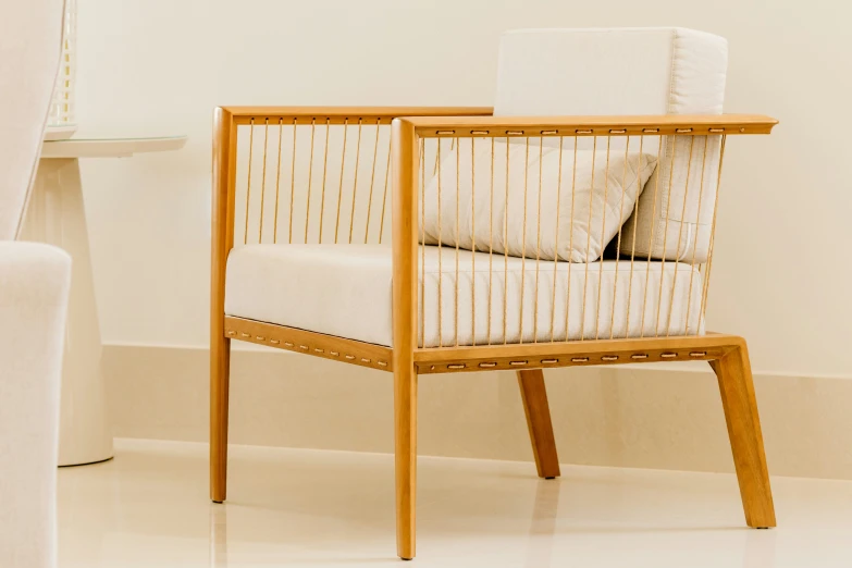 a light wood and upholstered chair with beige and white cushions