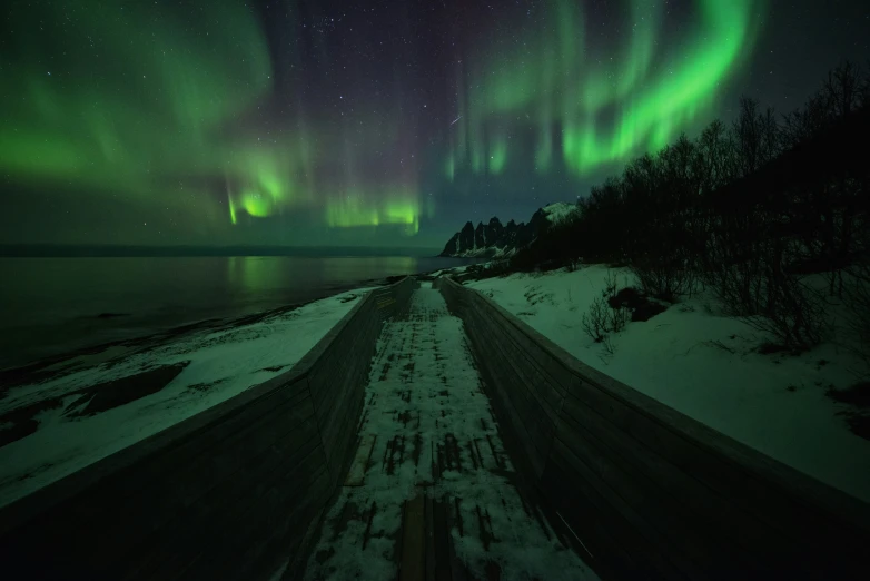 an icy road is under the aurora bores