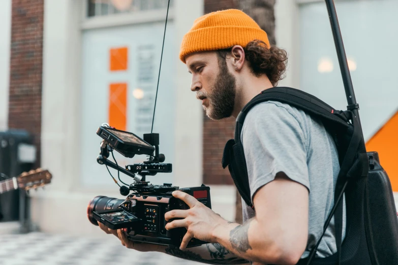 a man with a hat and camera holding soing