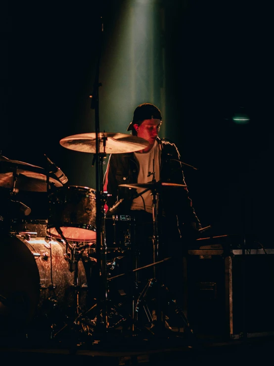 a drummer sitting on a stage behind a microphone