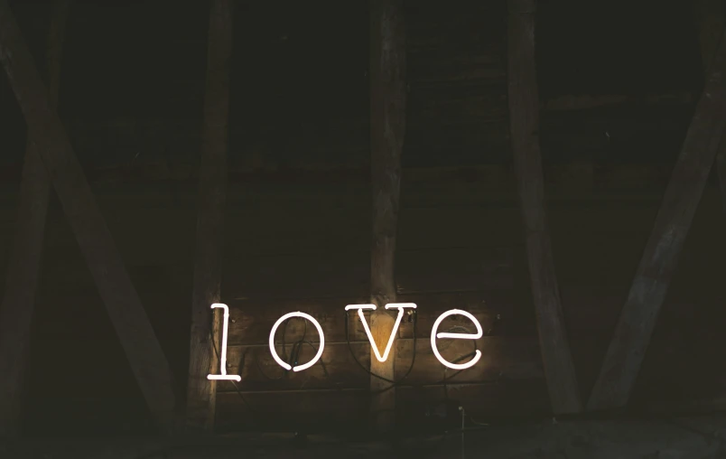 a neon sign saying love with the word love behind it
