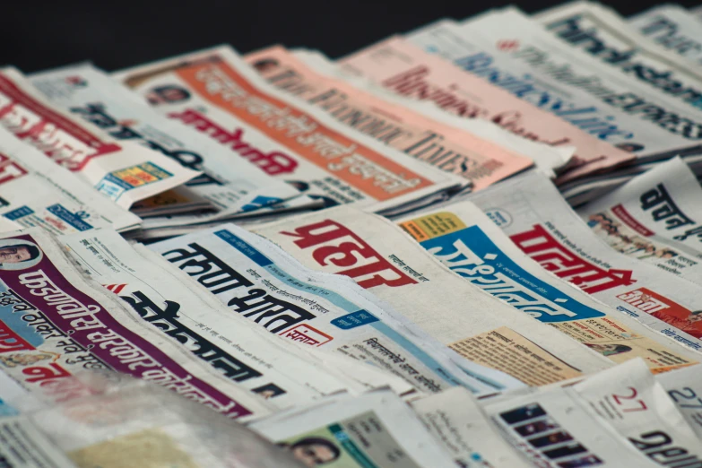 a stack of newspaper pages that is stacked to create a wall hanging