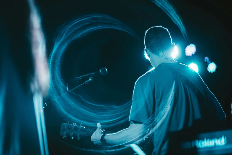 a guy with headphones on holding a guitar