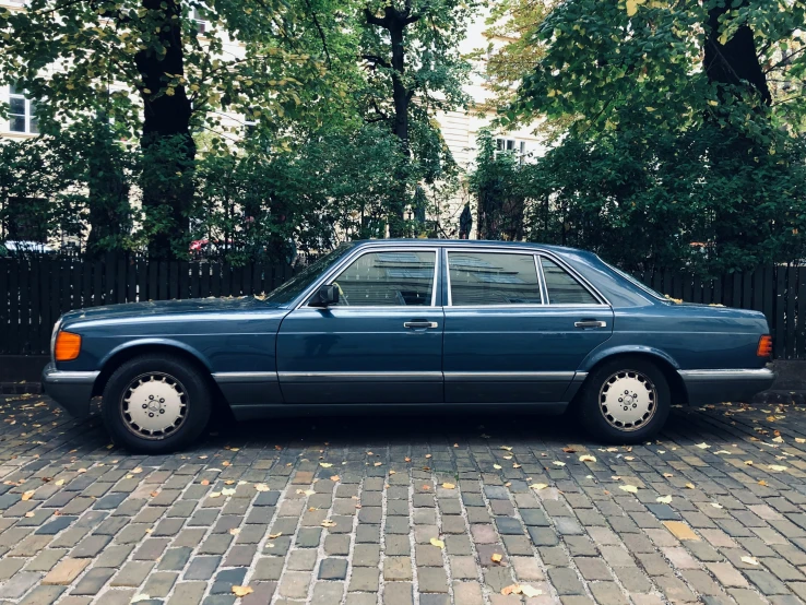 a blue car parked on a brick road