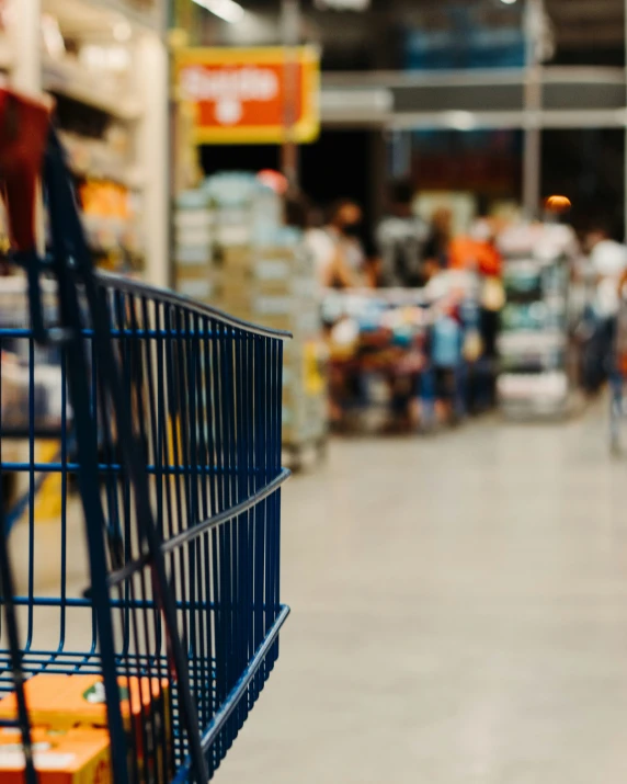 a shopping cart at a store full of people