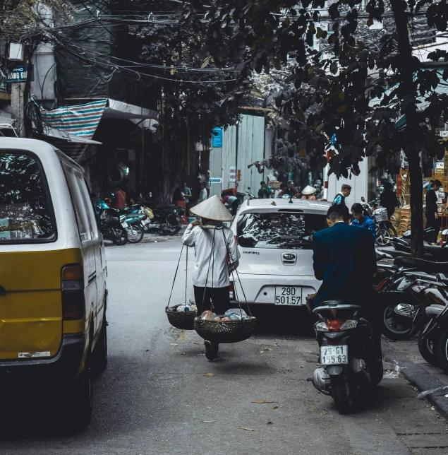 a motorbike pulling a passenger in a cart in front of a yellow van